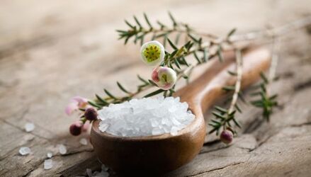 Arrangement von Peelingextrakt in einer Schale, im Hintergrund Gästetücher und Lavendel.